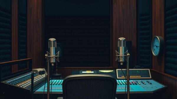 Studio de radio vide la nuit avec console fermée et micros sur pied, lumière tamisée.