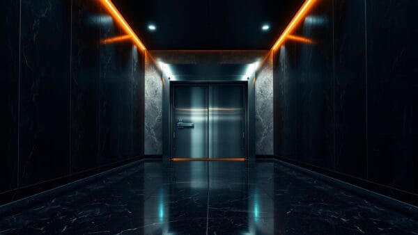 Couloir institutionnel sombre avec porte blindée entrouverte au fond, éclairage vert et ambre.