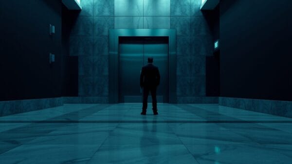 Porte de tribunal en acier entrouverte au bout d'un couloir institutionnel sombre, silhouette au loin.