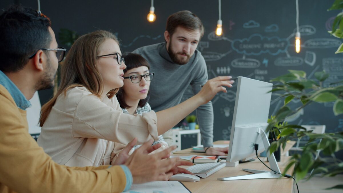 Une équipe réunit ses collaborateurs autour d'un ordinateur pendant une formation en entreprise.